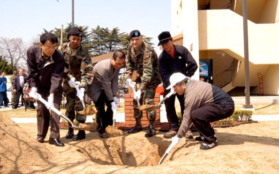 At Camp Henry in Taegu, South Korea, Tuesday, Oficials of the Nam-gu district of Taegu join Camp Henry officials in a tree-planting to mark South Korea's Arbor Day, a national holiday. The officials were guests of Army Col. Donald J. Hendrix, third from right, commander of the Area IV Support Activity at Camp Henry.