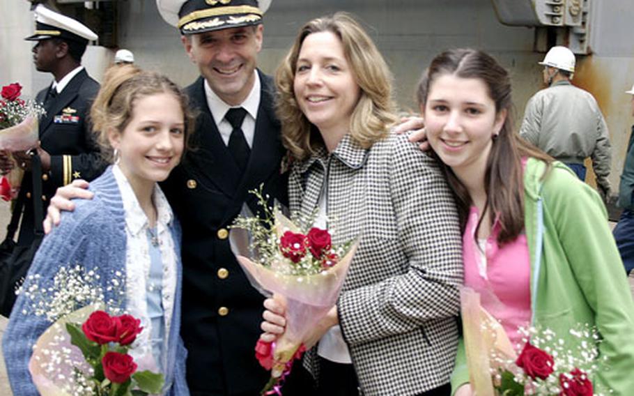 Capt. Mark E. Donahue, Commander Amphibious Squadron Eleven, with his wife Ruth and daughters Wednesday at the India Basin at Sasebo Naval Base.