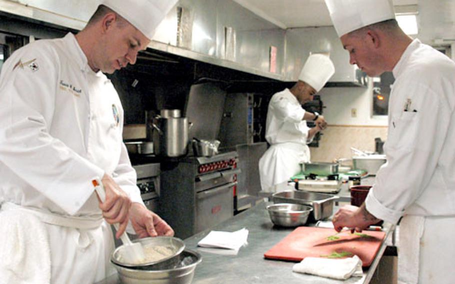 Chief Warrant Officer Travis Smith, left, Spc. Jay P. Ruff, right, and Pfc. Francisco Elias work through the night Tuesday at 305th Quartermaster Company dining hall at Yongsan Garrison, South Korea, to prepare their entries for the Seoul International Tourism and Food Expo. Last month, Smith and his team took the gold medal for best installation in the 30th annual U.S Army Culinary Arts Competition.