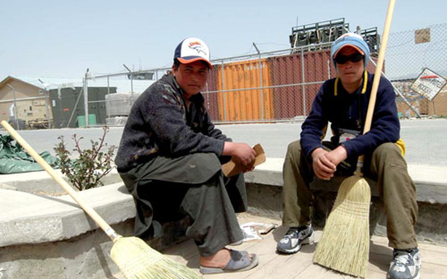 Mujeeb, left, and Azizullah take a break after sweeping the porch of the Bagram Air Base Pat Tillman USO Center. They are among the 19 local kids who are in Sergeant Major's Good Boys and Good Girls program at the base.