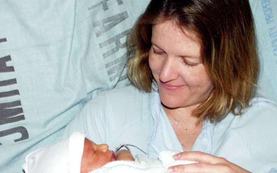 Air Force Staff Sgt. Sarah Lukens cuddles with her 2-day-old son, Braxton Hunter Lukens, on Monday at Landstuhl Regional Medical Center. While Lukens delivered at Landstuhl, some pregnant women are having to give birth in German hospitals because of a rise in military pregnancies.