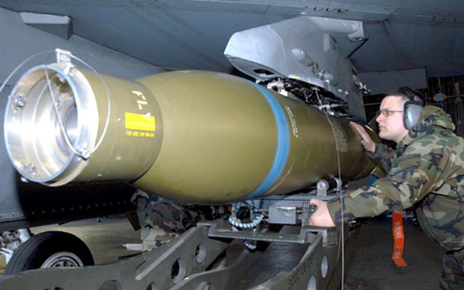 Staff Sgt. Michael Ward of the 555th Fighter Squadron at Aviano Air Base, Italy, loads a 2,000-pound laser-guided bomb onto an F-16 fighter jet Tursday morning. The high cost of the war on terrorism has forced Air Force bases in Europe to trim some non-war-related programs to cut costs.