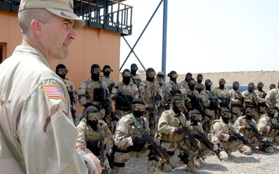 U.S. Army Col. Ted Westhusing, senior advisor for the Counter Terrorism Special Operations training program, praises Iraqi members of the Emergency Response Unit for a job well done Monday after the teams stormed a training building and shot targets depicting hostage takers without shooting the hostages or each other.