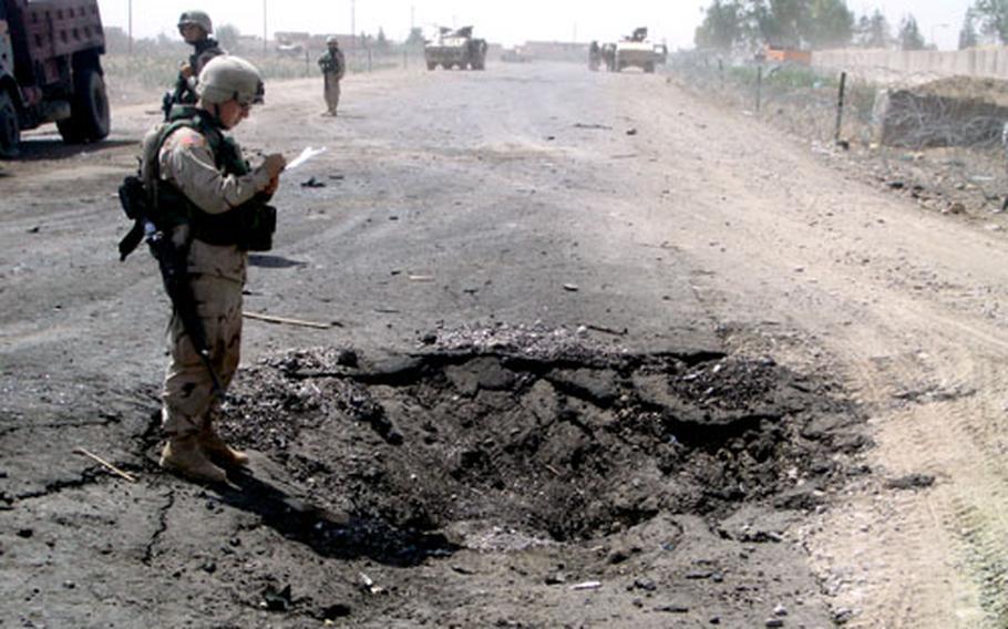 A soldier from the 1st Infantry Division’s 1st Battalion, 33rd Field Artillery, looks into the crater left by a suicide car bomb. The blast on June 1, 2004, outside the front gate to Forward Operating Base Summerall killed 11 and injured 32, most of them Iraqi laborers who worked for a contractor making improvements to the base.