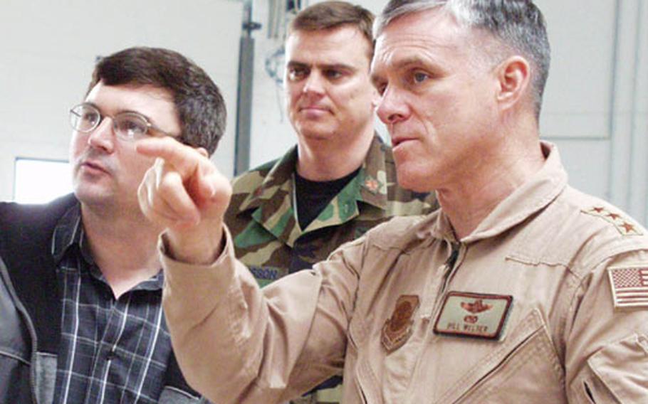 Lt. Gen. Bill Welser, right, commander of the 18th Air Force, talks with Larry Jecklin, left, the 726th Air Mobility Squadron transfer program manager, during a tour at Spangdahlem Air Base on Thursday. Welser visited Spangdahlem on the way to the Middle East.