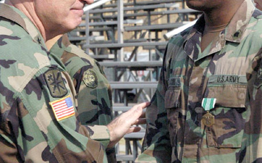 Maj. Gen. Donald Ryder, the Army's top law enforcement officer, thanks Pfc. Terrence Jacobs for possibly saving the life of a Korean woman earlier this month just outside Yongsan Garrison in Seoul.