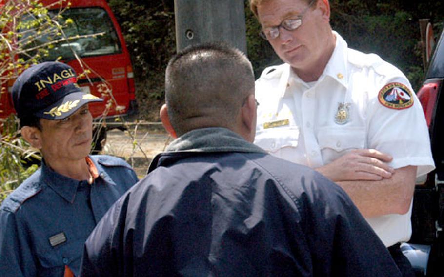 Mark Lawler, right, fire chief for Yokota's 374th Civil Engineer Squadron, conducts a site survey with Inagi City Fire Department officials on Tuesday during the base's full-spectrum threat-response exercise at nearby Tama Hills Recreation Center.