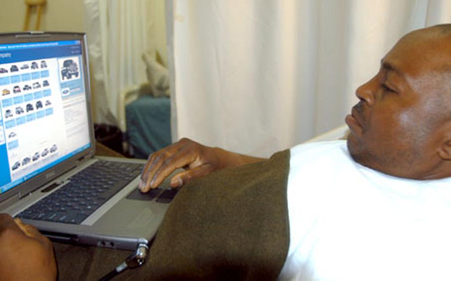 Sgt. Charles Watkins, a Humvee driver with 155th Infantry Battalion from Mississippi, logs on to the Ford Motor Co. Web site to check out truck prices, on one of the new wireless laptops donated to the 86th Combat Support Hospital in Baghdad by the Wounded Warrior program out of Omaha, Neb.