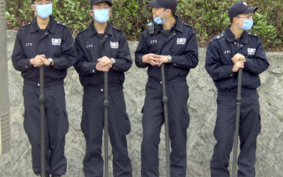 Korean National Police standing duty outside the U.S. Army's Yongsan Garrison in Seoul on Wednesday wear dust masks to protect themselves from the dust in the air.