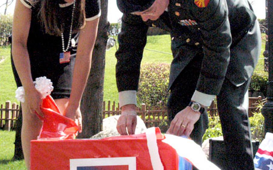 Lindsay Laughridge, 13, and Area II Commander Col. Timothy McNulty open a gift for Lindsay, part of her award for being the youth Volunteer of the Year.