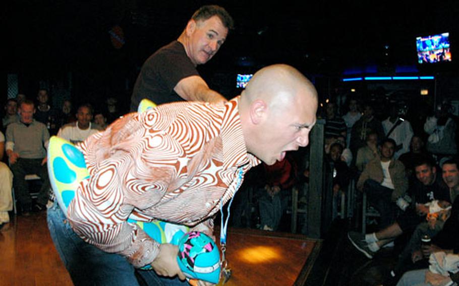 Hypnotist Chuck Milligan, standing in the background, hypnotized Petty Officer 1st Class Don Acker on Thursday at Sasebo Naval Base’s Galaxies Club and suggested that Acker was the extremely territorial lifeguard at a swimming pool in which various swimmers were relieving themselves. Acker, complete with a lifeguard’s whistle and float, told everyone to get out of the pool.