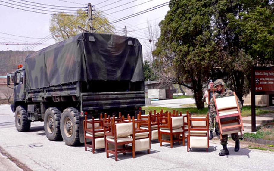 Soldier carries chairs Wednesdday from the former dining hall at Camp Giant, which closed recently in South Korea.