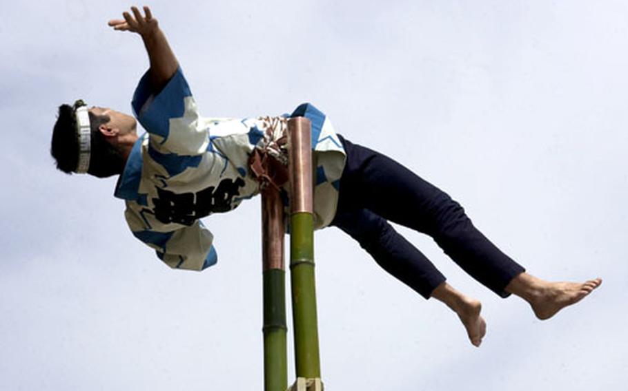 Fussa Fire Department personnel put on an acrobatic demonstration on top of a ladder during last year’s Japanese Culture Festival, which attracted nearly 4,000 people. Yokota officials hope to achieve the same turnout this year.