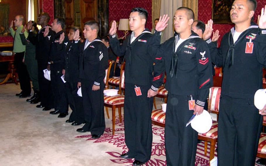 Seventeen military members raise their right hands and read the oath of allegiance to the United States during a naturalization ceremony Thursday. The ceremony, held at the U.S. Embassy in Rome, was the first large ceremony held in Italy for military members.
