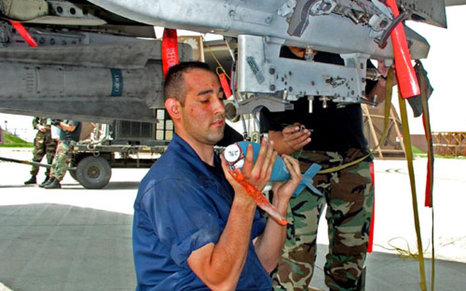 Senior Airman Joshua Rodriguez Weapons loads a 25-pound practice bombs on one of the squadron's A-10 attack planes. To the rear is his supervisor, Staff Sgt. Percival Cabase.