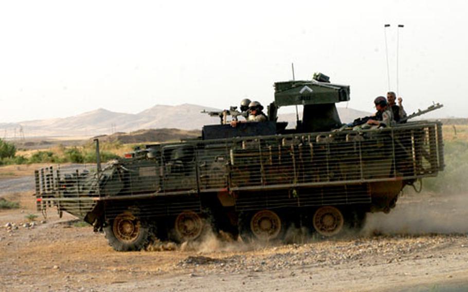 Soldiers from Delta/52 Infantry Company, 1st Stryker Brigade, 25th Infantry Division, patrol with a Stryker vehicle near the Tigris River in Iraq.