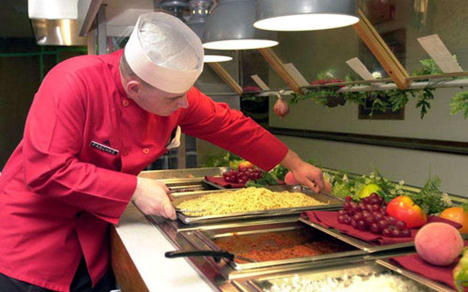 Lance Cpl. Raymond Paschke, assistant chief cook at Camp Foster’s Mess Hall 488, stocks the main food line at the facility. The dining operation recently won the Maj. Gen. W.P.T. Hill award for the Corps’ Best Jointly Operated Garrison Mess Hall. A total of 24 Marines and 57 Master Labor Contract employees keep the facility running, feeding about 1,200 people each day.