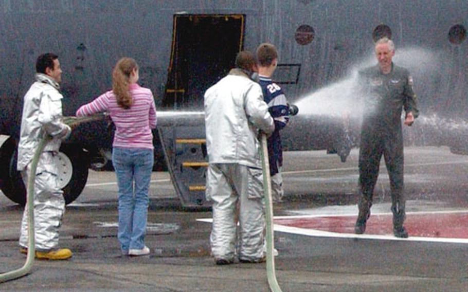Col. Mark Schissler, the 374th Airlift Wing commander, is "hosed down" after his final C-130 flight at Yokota Air Base, Japan, on Tuesday.
