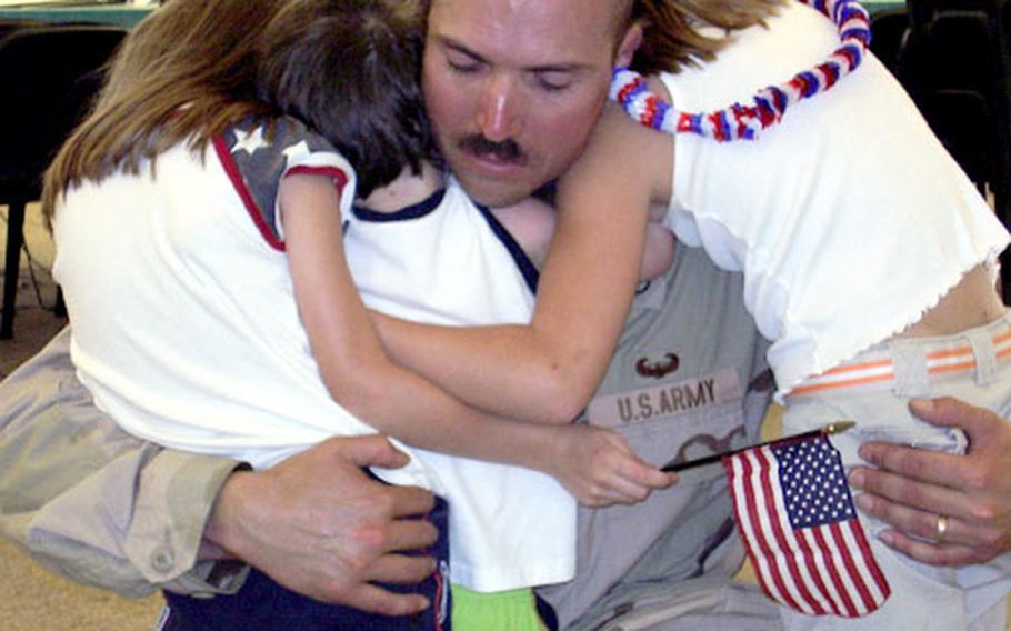 Staff Sgt. Francisco Huereque Jr., a maintenance chief with Company A, Tactical Unmanned Aerial Vehicle unit of the 101st Military Intelligence Battalion, greets his children, Cheyenne, 9, Nicole, 7, and Ian, 3, at his platoon’s welcome home ceremony on Tuesday in Würzburg, Germany.