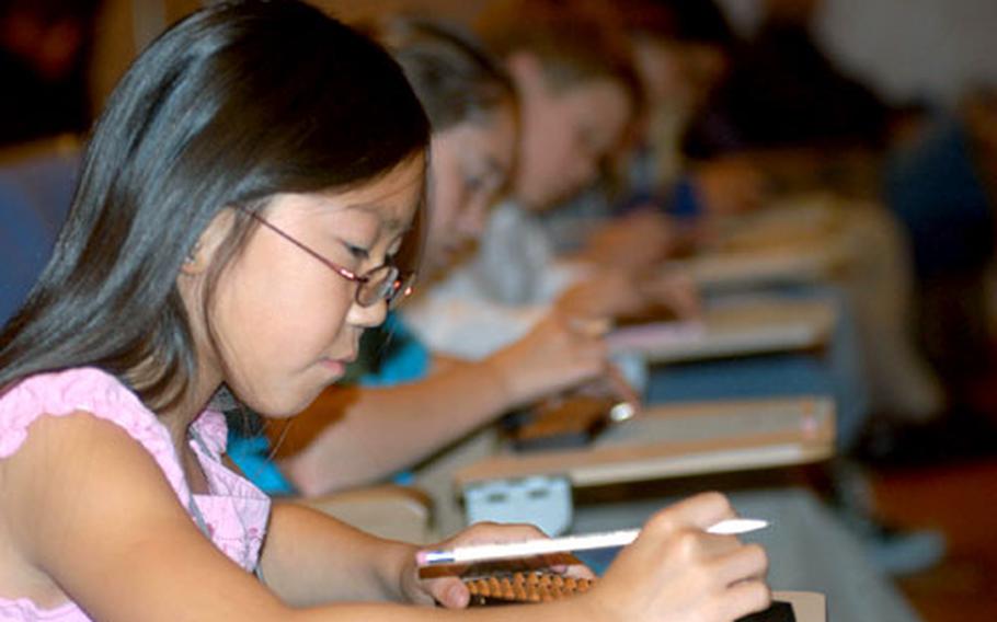 Hannah Sutherland, a fifth-grader at Cummings Elementary School, calculates a math equation on an abacus during a soroban competion at the Misawa International Center on Wednesday.