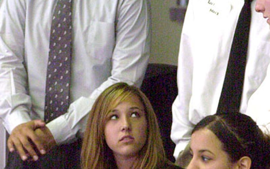 Caitlin Baker, seated left, who portrayed Adolf Hitler in Baumholder High School’s “Power of One” debates, looked to see which fellow historical figures lined up behind her as the final voting began on Thursday. With her, from left, are Winston Churchill (Clayton Eng), Karl Marx (Andrew Oppliger) and Pablo Picasso (Yasemin Johnson).