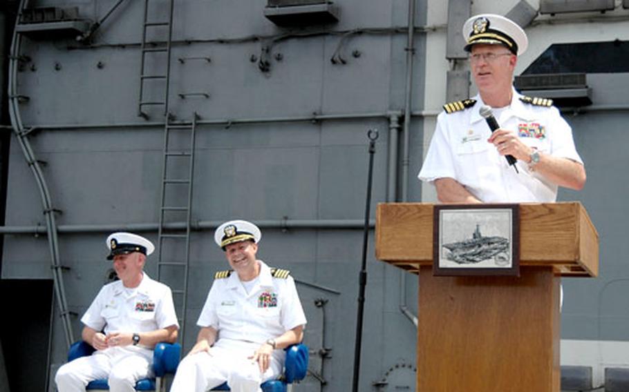 Capt. Tom Parker gives a speech before turning over command of the USS Kitty Hawk to Capt. Ed McNamee during a change-of-command ceremony Thursday on the flight deck.