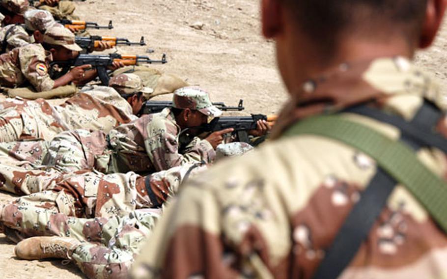 An Iraqi soldier watches as dozens of soldiers try to hit their targets at a shooting range at Camp Justice in Baghdad.