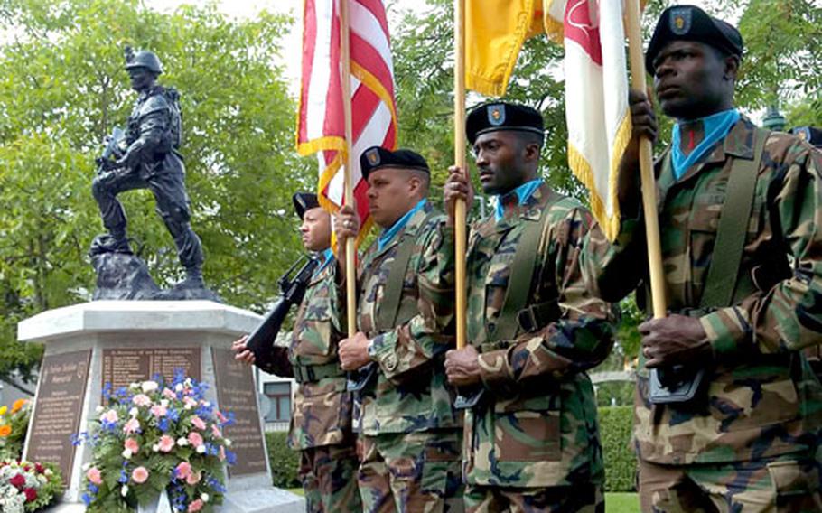 An Army color guard stands in front of the Fallen Soldier Memorial statue at the 1st Infantry Division service in Würzburg, Germany, on Monday.