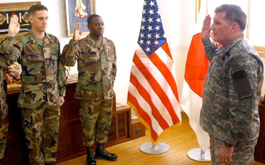 U.S. Army Chief of Staff Gen. Peter Schoomaker, right, re-enlists Sgt. Sos Jackson and Sgt. 1st Class Lorenzo Lewis on his visit to Camp Zama, Japan, on Wednesday.