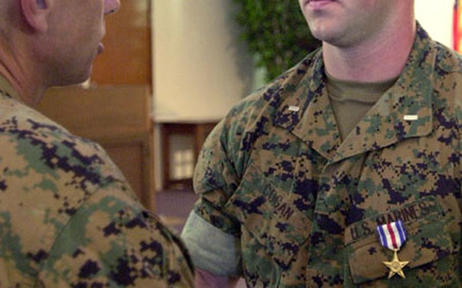 1st Lt. Thomas E. Cogan IV, executive officer of 2nd Battalion, 4th Marine Regiment's "E" Company, is congratulated by Lt. Gen. Robert R. Blackman Jr., III Marine Expeditionary Force commander, after Blackman pinned on the Silver Star.
