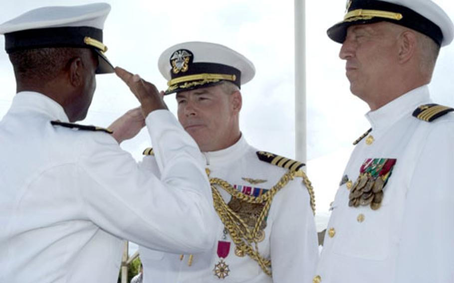 Rear Adm. Arthur Johnson, left, commander of U.S. Naval Forces Marianas, returns the salute of Capt. Robert McNaught, the out-going chief of staff and commanding officer of Naval Base Guam, during a change of command ceremony Friday on Guam. Capt. Kenneth Freeman, right, relieved McNaught as commanding officer of the naval base.
