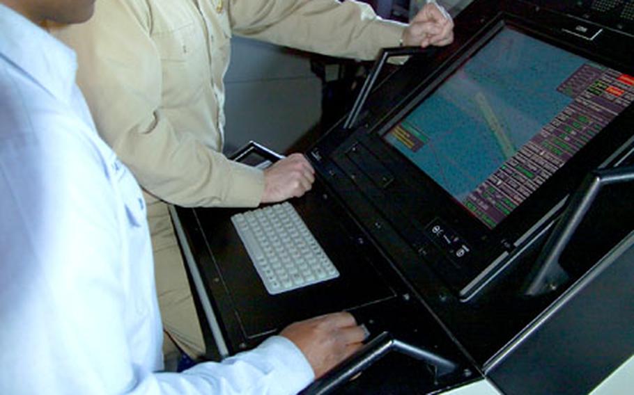 USS Cape St. George navigator Lt. j.g. Tim Shanley, right, and Quartermaster Akil Brathwaite monitor the ship’s position using the Navy’s new electronic navigation technology.
