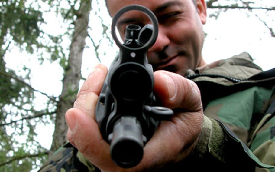 Italian army Warrant Officer Serrau Massimiliano from Milan relishes the opportunity to toy around with the German HKMP5 submachine gun during the Monte Kali international shooting competition in Messel, Germany, on Saturday. International troops, government agencies, and shooting clubs from 12 countries came together to qualify on one another’s weapons and to shoot at the Monte Kali M16 firing range.