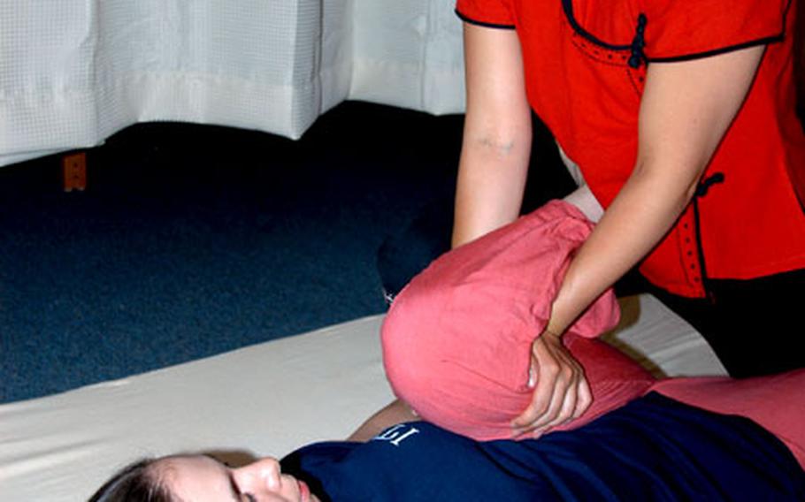 Yoko Miara, a Thai massage therapist, stretches Senior Airman Misti Reisz during a massage therapy session Thursday night at Potter Fitness Center, Misawa Air Base, Japan.