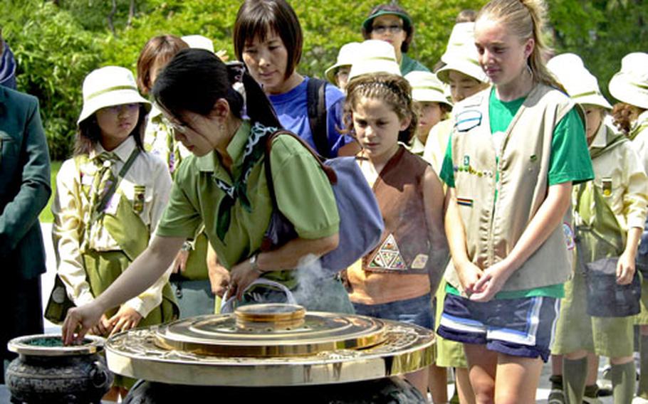 American and South Korean Girl Scouts burn incense Saturday at the base of the Memorial Tower at the National Cemetery in Seoul.