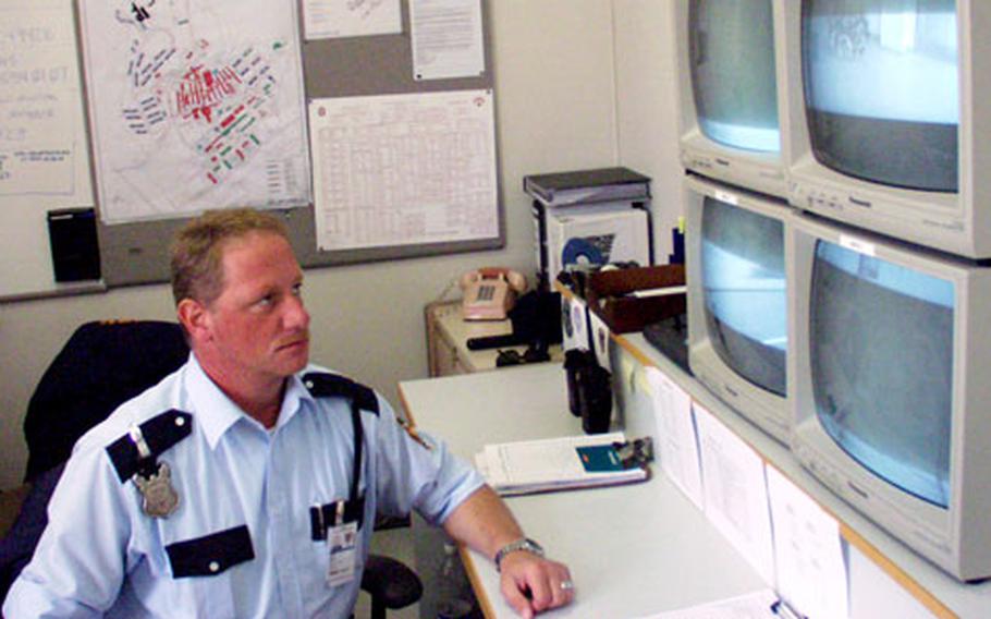 Werner Stephan with Pond Security Service checks a bank of security camera monitors at Landstuhl Regional Medical Center in Germany.