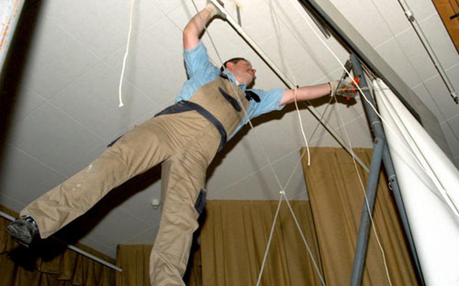 Kurt Wolff, an Army and Air Force Exchange Service worker, takes down the screen at the Patch Barracks theater.