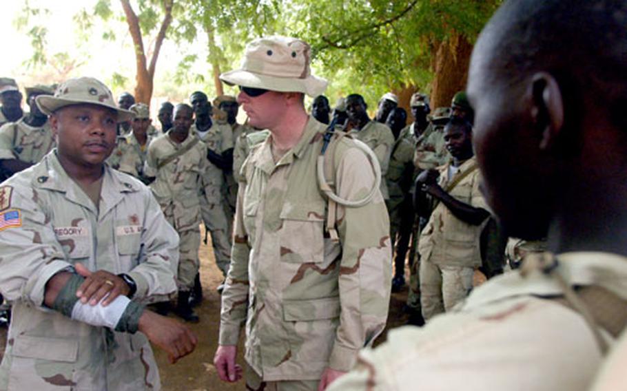 Staff Sgt. Eric Gregory, left, and Spc. Brian Smith of the Landstuhl, Germany-based 160th Forward Surgical Team train Nigerien soldiers on how to apply field dressing to a wound on Friday.