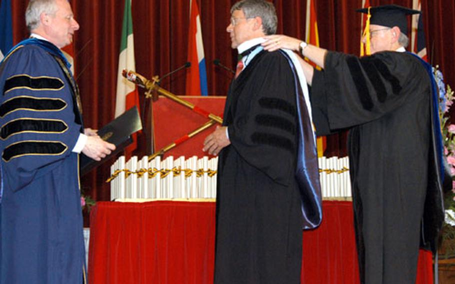 At the University of Maryland University College commencement ceremony in May, Professor Detlef Junker, center, director of the Heidelberg Center for American Studies, received an honorary degree from UMUC President Gerald A. Heeger, left, and school director John C. Golembe. Junker’s comments as the ceremony’s keynote speaker irked some graduates and attendees.