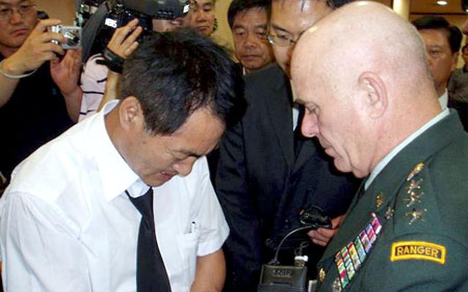 U.S. Forces Korea commander Gen. Leon LaPorte, right, meets Saturday with the brother of a South Korean woman who was killed after being hit by a U.S. military vehicle Friday near Camp Casey, South Korea.