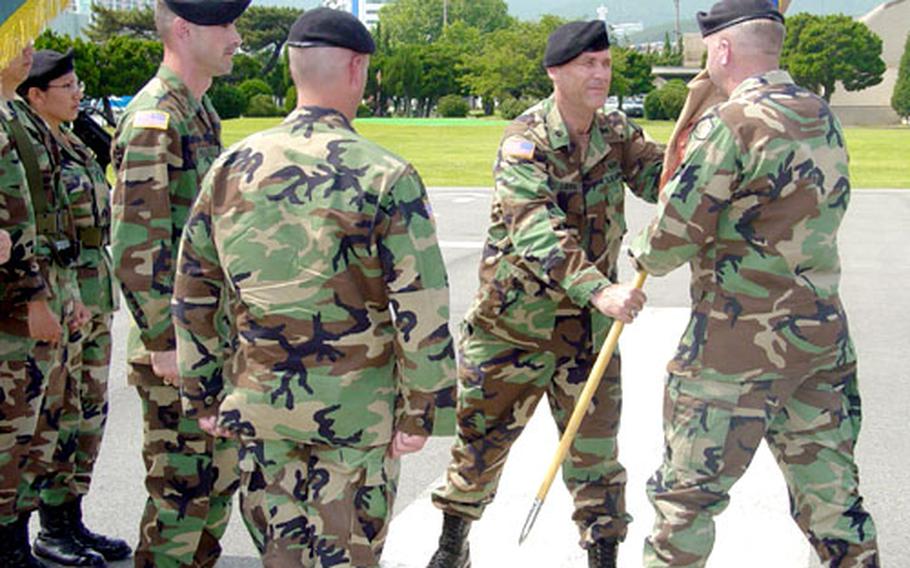 Lt. Col. Jeffery K. Ludwig, second from left, hands a guidon to Col. Charles J. Toomey Jr., commander of the Army's Materiel Support Center-Korea, at change-of-command ceremony at Camp Hialeah in Pusan, South Korea, on Wednesday. Ludwig ended his tour as commander of both Camp Hialeah Garrison and Pusan Storage Facility, and was replaced by Lt. Col. Roger Dansereau.