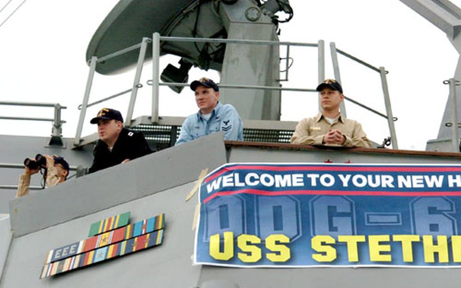 Officers and sailors of the USS Curtis Wilbur watch from the bridge wing as the USS Stethem arrives at Yokosuka Naval Base, Japan, on Friday.