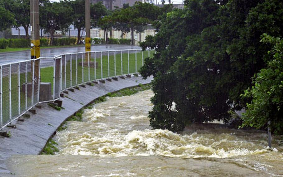 Fred Zimmerman / S&S A drainage ditch on Camp Foster, Okinawa, swells nearly over the edge after a long downpour Friday.