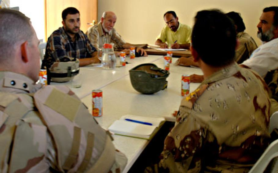 First Lt. Jason Warren meets Tuesday afternoon with the Neighborhood Advisory Council in Khadra, an area in western Baghdad. Six men from the council came, as did a captain from the Iraqi army.