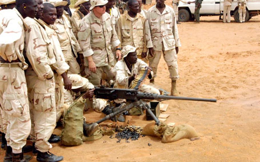 Nigerien army Pvt. Namane Idi takes target practice with a .50-caliber machine gun while a Green Beret from the Alabama-based 20th Special Forces Group supervises. The Green Beret is part of Team Niger, participating in the Flintlock 05 exercise in which U.S. troops are training armies from northern Africa.
