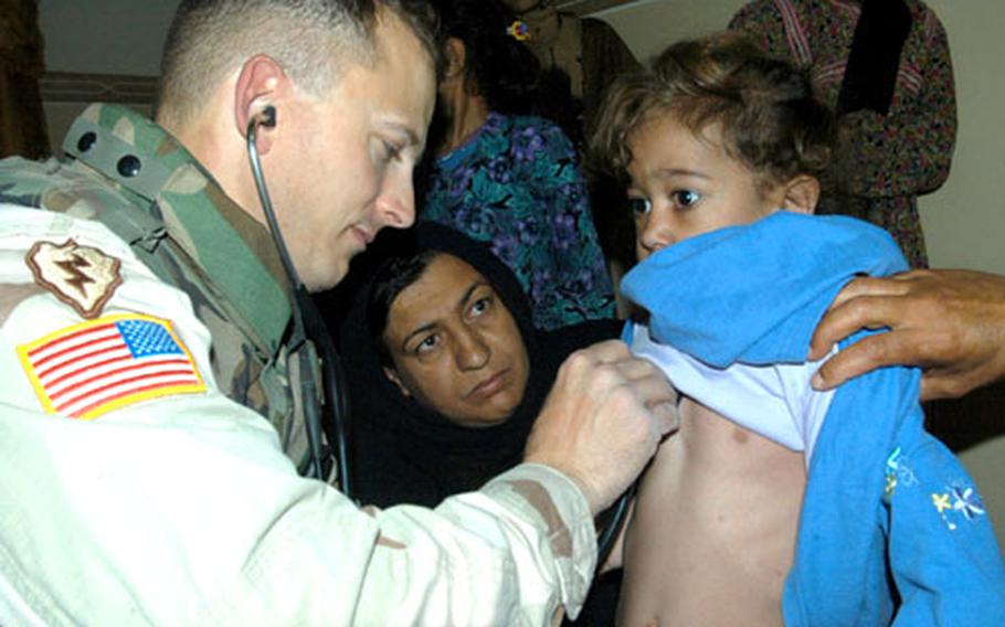 Dr. (Maj.) Dave Brown, with 1st Battalion, 24th Infantry Regiment, 1st Brigade (Stryker Brigade Combat Team), 25th Infantry Division, listens to heart and lung sounds of 5-year-old Rhma Taha Ahmed last month in Mosul.