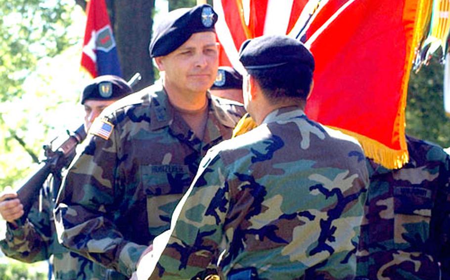 The 1st Infantry Division's new commander, Maj. Gen. Kenneth W. Hunzeker, takes the division’s colors from V Corps Commander Lt. Gen. Ricardo Sanchez during a change of command ceremony Monday in Würzburg, Germany.