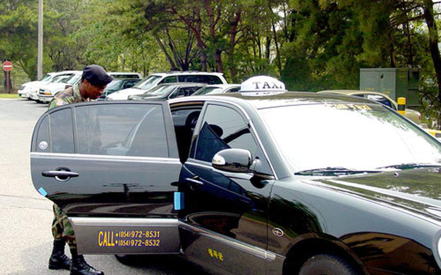 Army Sgt. 1st Class Terry Newby looks inside a taxi on Monday that is part of a new service at Camp Carroll in Waegwan, South Korea. Newby is Camp Carroll’s installation noncommissioned officer-in-charge.