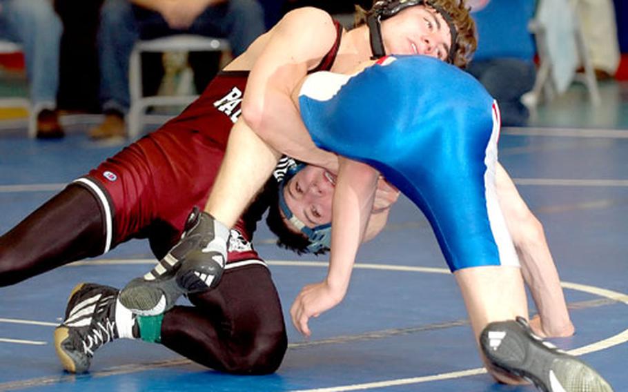 Baumholder’s David Crow, top, tries to flip Ramstein’s Ryan Gough during their first-place match in the 119-pound division at the Ramstein regional wrestling tournament in Ramstein, Germany, in February. Because of budget cuts, Baumholder is considering dropping wrestling and other sports.