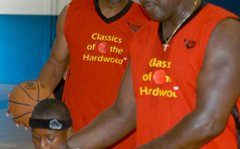 6-11, 310-pound Darryl Dawkins towers over 11-year-old Anthony Davis during a clinic Thursday put on by three former NBA players at Vicenza, Italy.